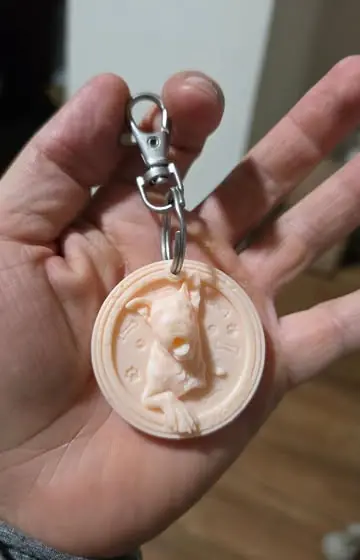 Llavero 3D personalizado con el relieve de un perro, sostenido en la palma de la mano