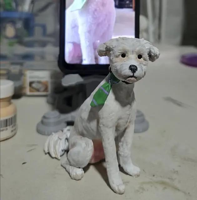 Figura 3D de Lucho, perro blanco de pelo rizado con corbata verde, pintada a mano